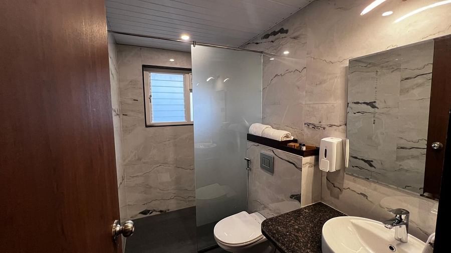 Grand suite washroom with a sleek design, featuring a shower cubicle and a sink at Mastiff Grand La Villae Resort, Lonavala